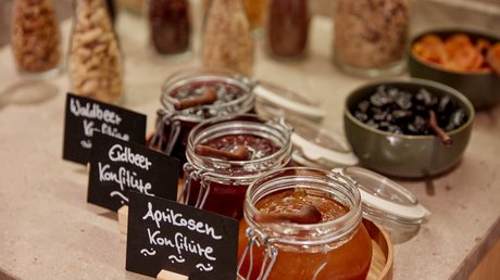 Aussicht auf Traumurlaub in Bad Tölz Gläser mit Waldbeer-, Erdbeer- und Aprikosenkonfitüre auf einem Tisch