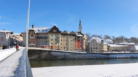 Aussicht auf Traumurlaub in Bad Tölz Winterlicher Blick auf bunte Häuser und einen Fluss in einer kleinen Stadt