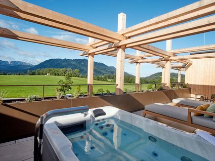 Your holiday in nature in Bavaria: Hotel BERGEBLICK Hot tub on terrace with loungers and mountain view under clear sky