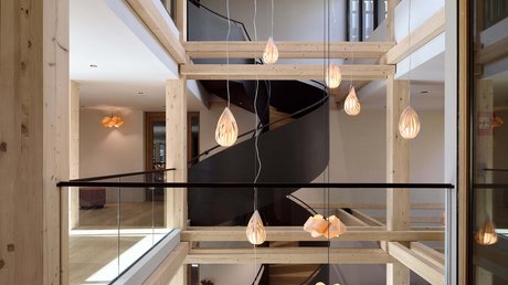 Aussicht auf Traumurlaub in Bad Tölz Moderner Innenraum mit Holzrahmen und schwarzer Wendeltreppe