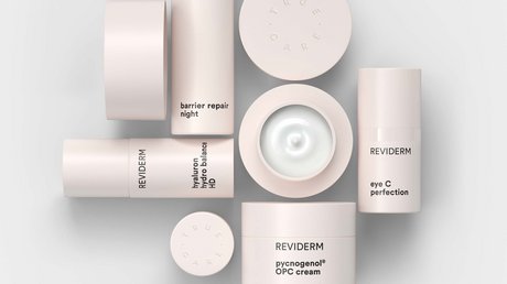 Aussicht auf Traumurlaub in Bad Tölz Verschiedene Reviderm Hautpflegeprodukte auf weißem Hintergrund