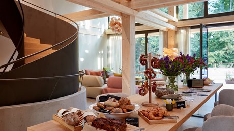 Aussicht auf Traumurlaub in Bad Tölz Moderne Wohnküche mit Holztreppe und Tafel voller Brot und Gebäck