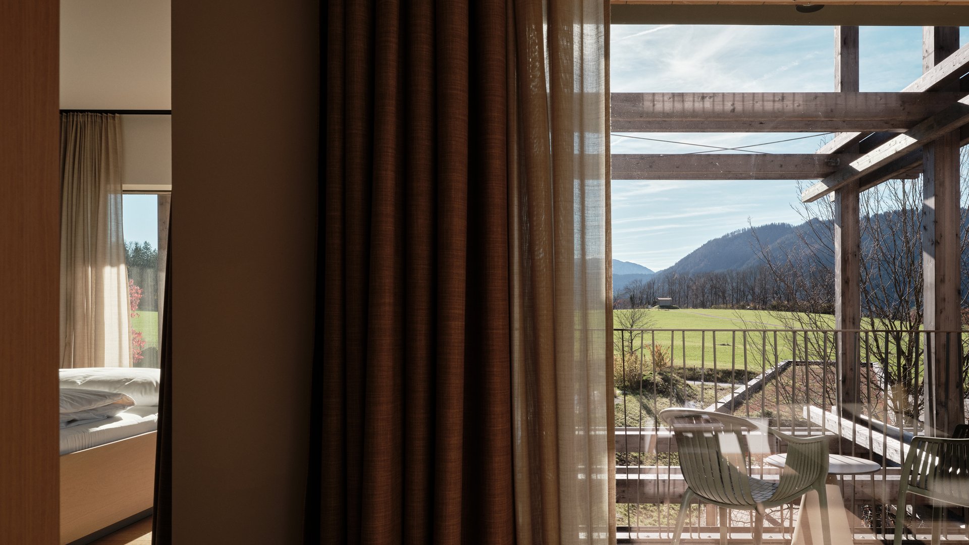 Garden suites in Bavaria: BERGEBLICK View through window with curtains to balcony and mountain landscape