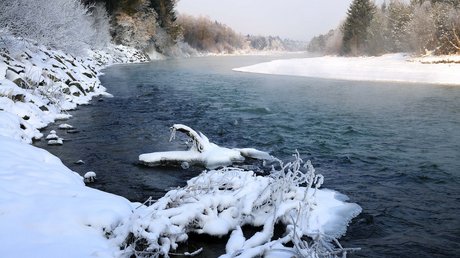 Aussicht auf Traumurlaub in Bad Tölz Verschneiter Fluss mit frostbedeckten Ästen und Bäumen im Winter