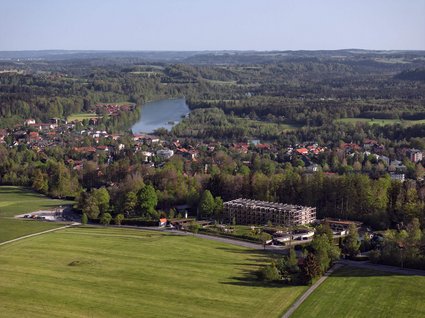 Your holiday in nature in Bavaria: Hotel BERGEBLICK Aerial view of green valley with river, forest, and buildings in rural area