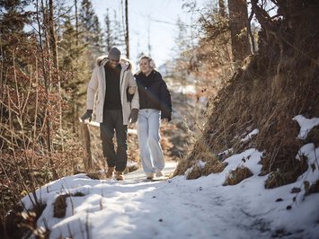 Winter bliss in Bad Tölz Couple walking on a snowy forest path in winter