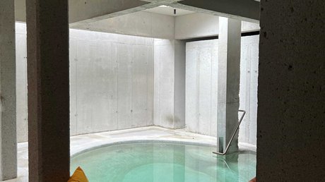 Aussicht auf Traumurlaub in Bad Tölz Moderner Innenpool mit bunten Kissen auf einer Sitzbank