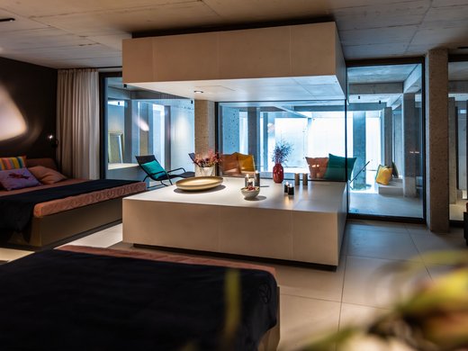Dein Retreat im BERGEBLICK Modernes Wohnzimmer mit Sofas, Glaswänden und dekorativem Zentrum mit Kerzen
