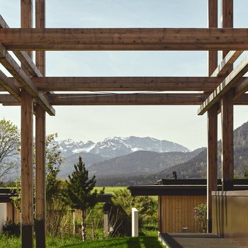BERGEBLICK: Ihr Hotel in Bad Tölz Holzbau mit Blick auf Berge und grüne Landschaft im Hintergrund