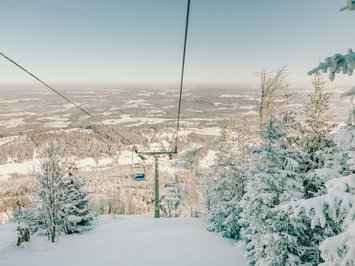 Winter bliss in Bad Tölz View of snow-covered ski lift and snowy trees in winter landscape