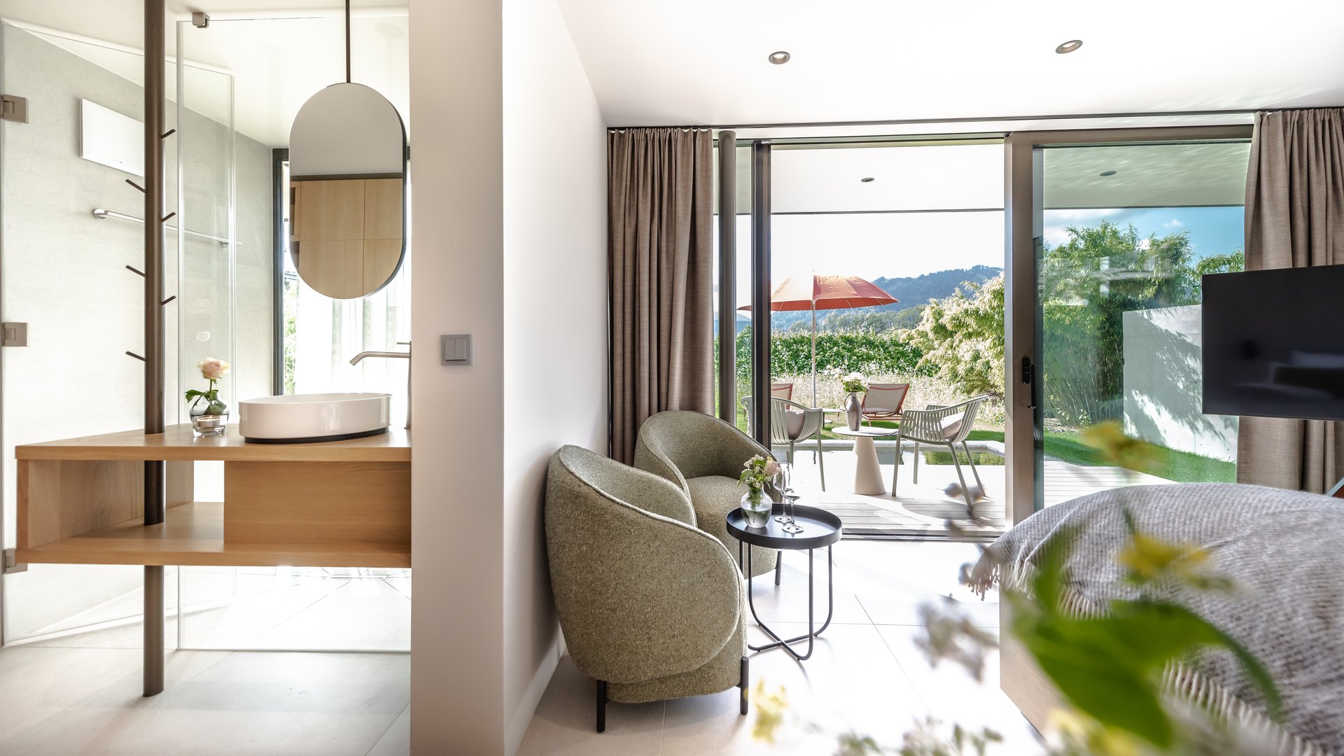 Garden suites in Bavaria: BERGEBLICK Bright hotel room with seating area and terrace overlooking garden