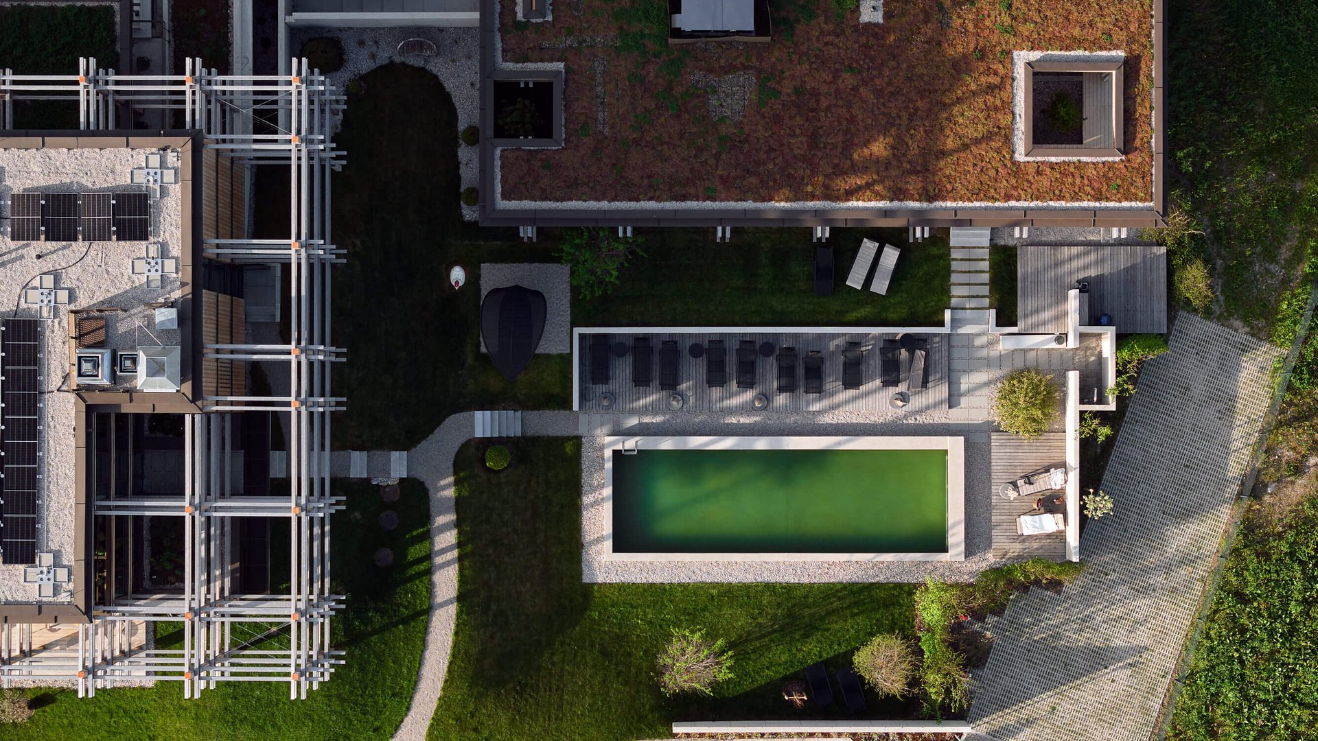 Your holiday in nature in Bavaria: Hotel BERGEBLICK Aerial view of modern building with green roof and swimming pool in the garden