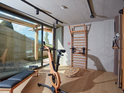 Dein Aktivurlaub im Hotel mit Fitnessstudio in Bayern Hell erleuchteter Fitnessraum mit Holzfahrrad, Trainingsbank und Kletterwand