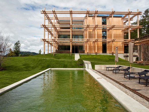 Your holiday in nature in Bavaria: Hotel BERGEBLICK Modern wooden house with pool and lounge chairs on green lawn