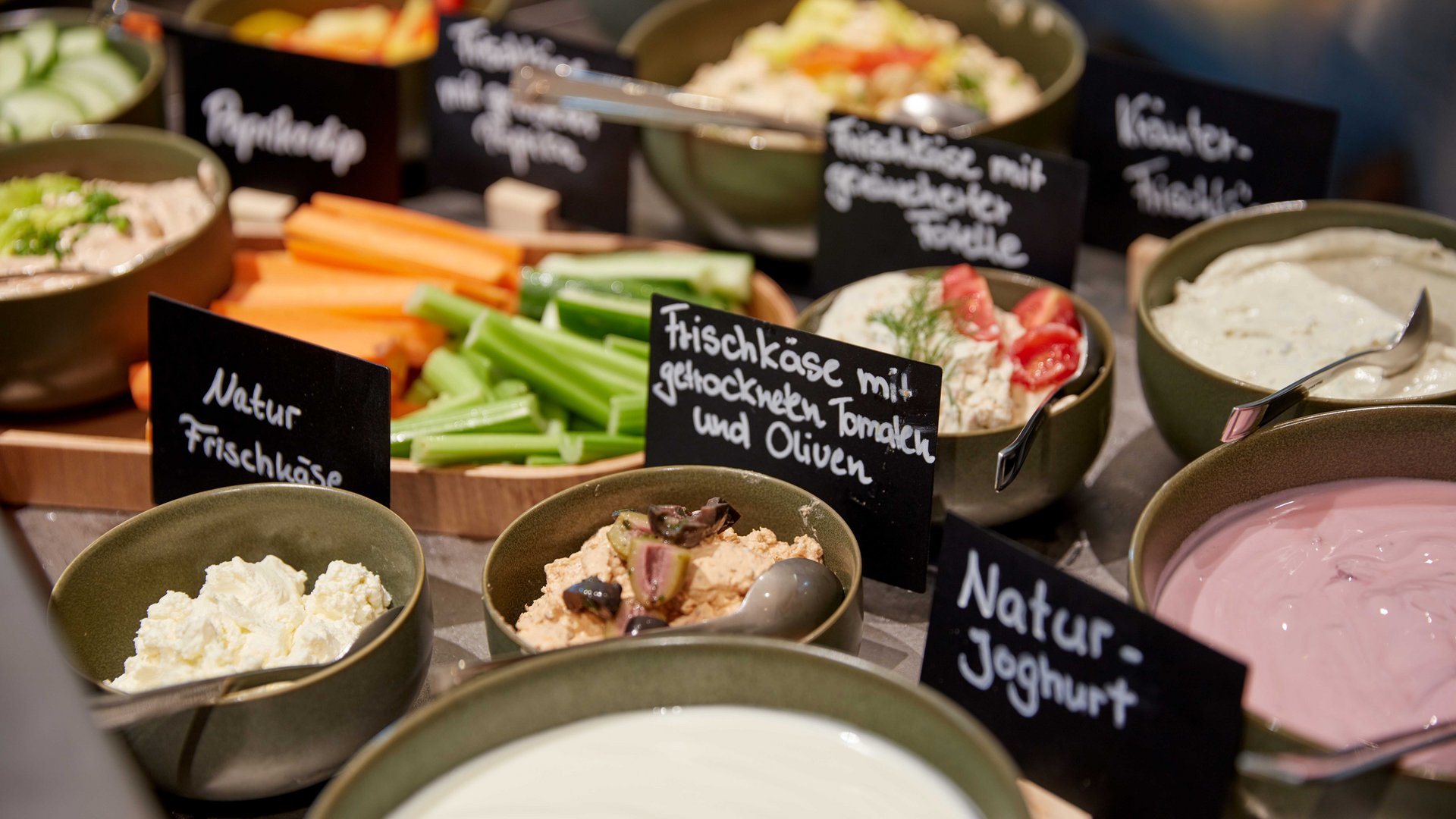 Bad Tölz: hotel with regional breakfast Various cream cheeses and vegetables in bowls with labels on a buffet
